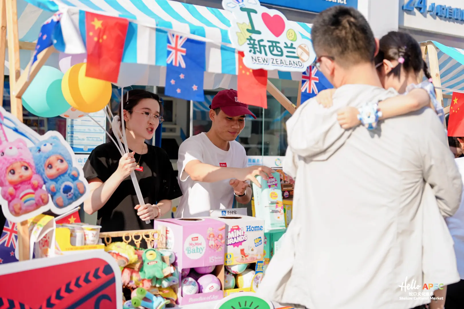 ZURU stall representatives showing toys to a family